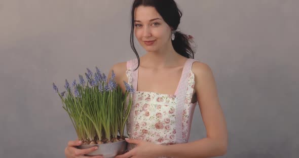 Woman Holding Bouquet of Flowers in Hands Indoors alt