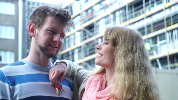 Couple On Front Of New House With Keys Ring