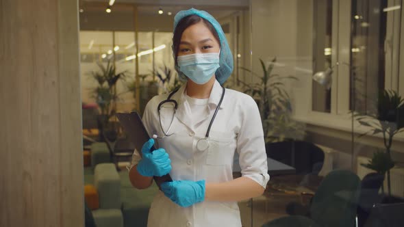Positive Asian Female Doctor Smiling at Hospital alt