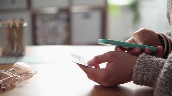 Young Woman Buys Online Using her Phone alt