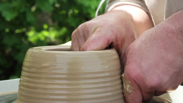 a Male Potter of Caucasian Ethnicity in a Work Shirt Makes a Bowl of Clay alt