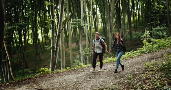 Backpacked Couple Walking in Forest