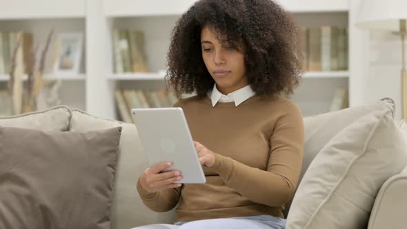 Young African Woman Using Tablet on Sofa alt