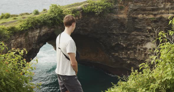 Close Up Shot of Male Tourist Looking at the Beautiful Cliffs of Broken Beach Pasih Uug in Bali alt