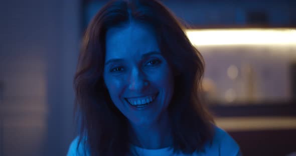 Smiling Young Woman at Home Watching Tv and Laughing alt