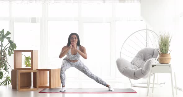 Athletic fit girl doing fitness aerobic exercises for booty in living room. alt