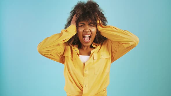 Ethnic Black Woman Shrugging Shoulders Asking Why Grabbing Head Screaming Being Upset Posing on Blue