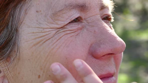 Granddaughter Hands Stroking Grandmother's Face. Old Woman Close-up. Hugging Mother and Grandmother.