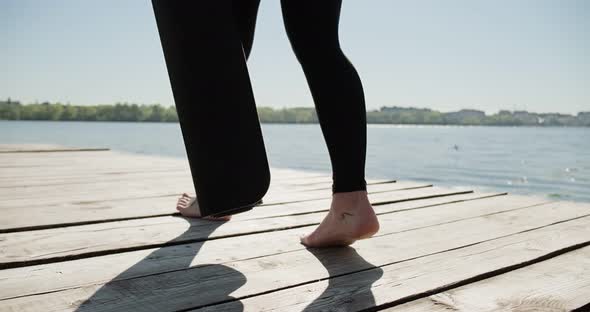 Young Blonde Woman Practicing Yoga on the Wooden Berth at Lake. Single Sport Healthy Training on