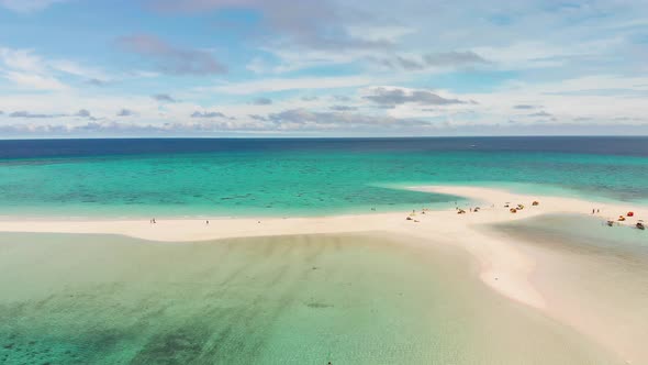 tourist enjoying their relaxing vacation on a tropical white sandy beach surrounded by blue turquois alt