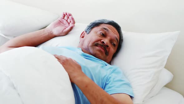 Senior man relaxing on bed 4k alt