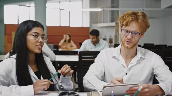 Diverse Multiethnic Young Male and Female Discussing Creative Ideas for Developing Design Project alt