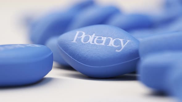 Pile of blue pills on a bright background. Heading camera movement. 4KHD alt