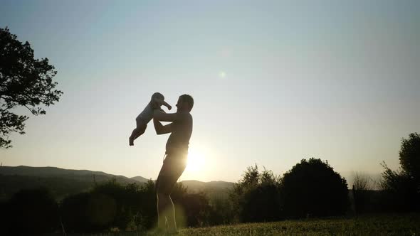 View of an Energetic Father Spinning His Little Boy and Rocking Him Up and Down alt