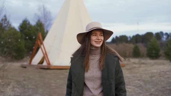 Young Beautiful Woman Walking Through Woods in Glamping Outside Teepee