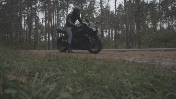 Wide Shot of Male Motocyclist Turning on Engine and Leaving. Confident Young Man in Helamet and alt