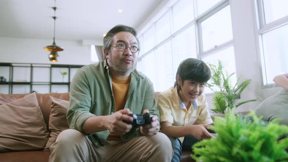 happiness cheerful asian family play video game together at home fun and excited