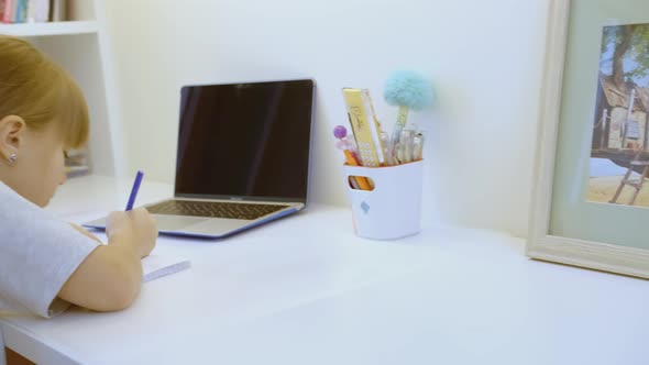 Girl is Sitting at Workplace in Children's Room alt