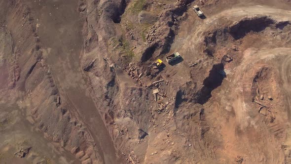Aerial View of Working Excavator in the Opencast Mine. Camera Flight Over Industrial Landscape. alt