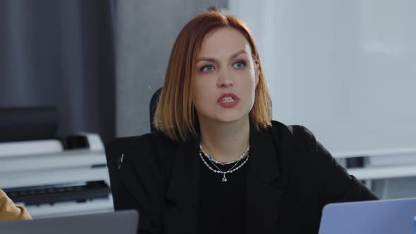 Closeup of a Young Woman Who Shows Graphs to Colleagues in the Office