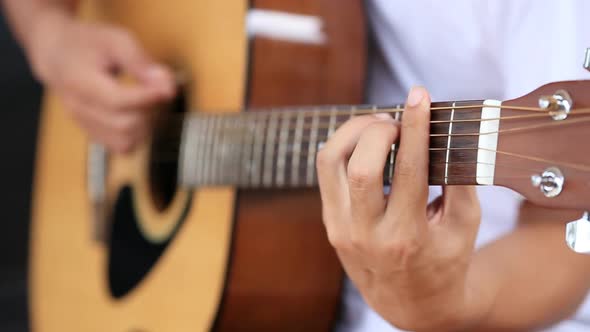 Close up of hand playing acoustic guitar