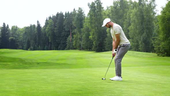 Young man playing golf on green lawn alt