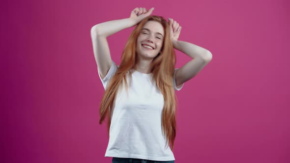 The Portrait of a Charismatic Young Woman Who Playfully Puts Her Hands to Her Head Like Bunny Ears alt