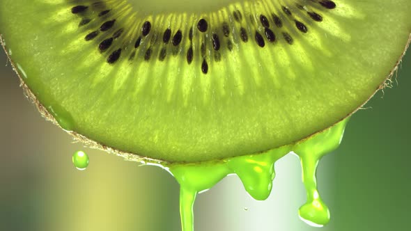 Super Slow Motion Macro Shot of Flowing Juice From Kiwi Slice at 500Fps alt