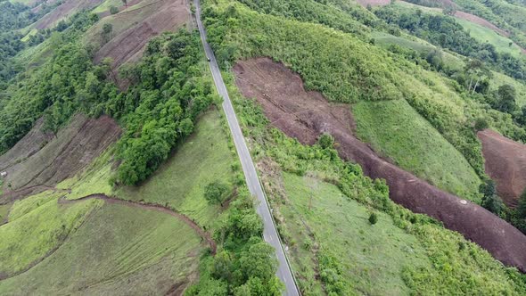 Aerial view of mountain road through tropical forest in countryside by drone