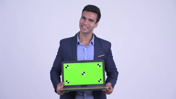 Happy Young Indian Businessman Talking While Showing Laptop