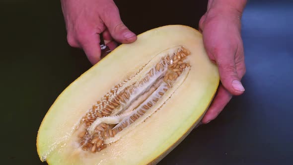Slicing ripe melon with a kitchen knife.