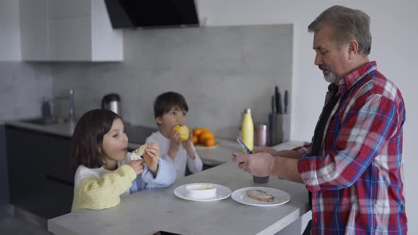 Two Small Children are Eating Sandwiches Made By Grandfather Slow Motion alt