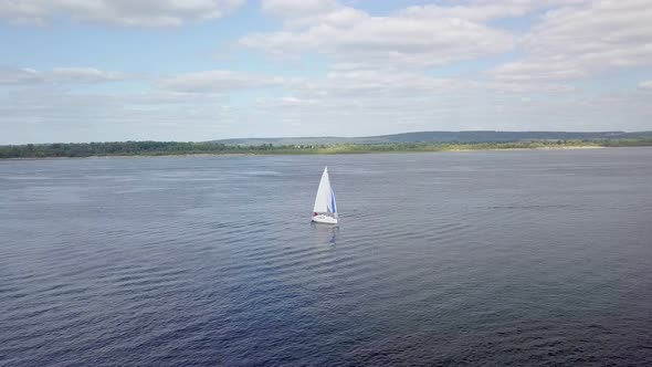 Aerial View of White Sailboat on River, Camera Is Flying Around