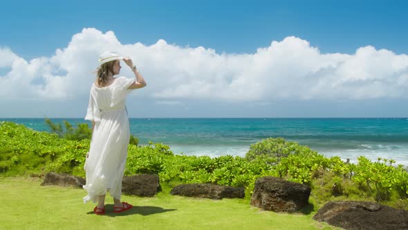 American Woman in Maxi White Boho Style Dress Looking at Teal Blue Ocean Hawaii alt
