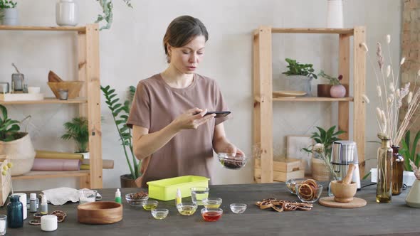 Woman Filming Various Spices In Glass Bowls alt