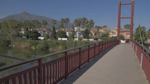 Puente de madera y hierro rojo cruce del rio / Marbella