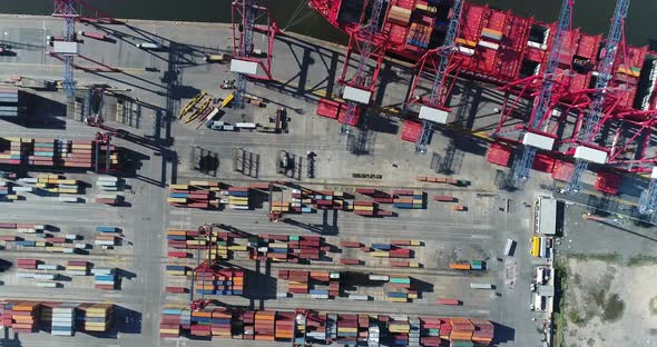 erial scene with drones. Container terminal of the port. Camera down with a view of ship and contain alt