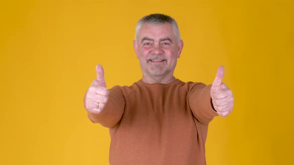 Cheerful Senior gray-haired man in white shirt showing thumb up alt