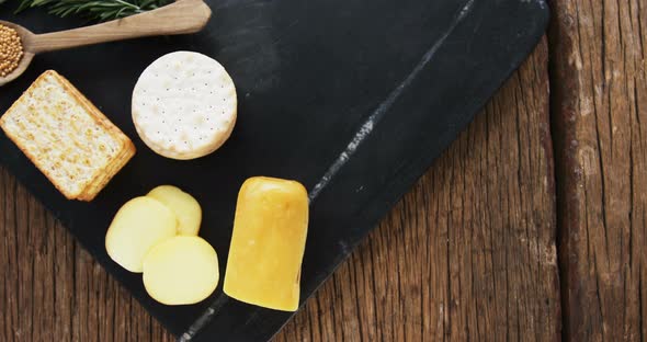 Sliced cheese with crispy biscuits, seeds, rosemary herb and sauce alt