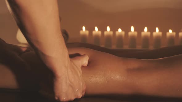 Young Woman Getting Legs Massage with Oil in Resort Spa Salon