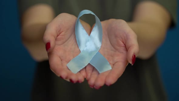 World Diabetes Day. Blue Ribbon Symbolic Isolated with Hand Support.