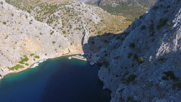 Small Fishing Harbor in a Narrow Valley Between Steep Walled Rocky Mountains alt