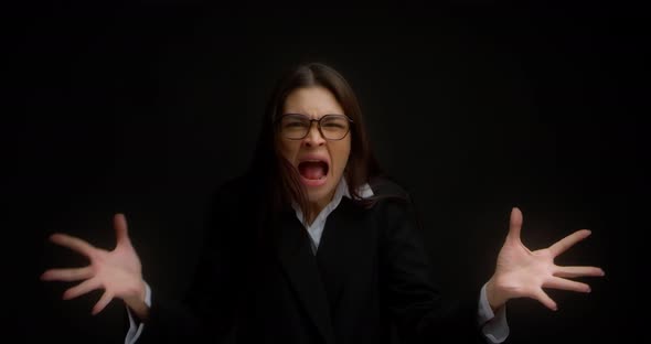 Woman with Glasses Shouting with an Aggressive Expression and Raised Hands