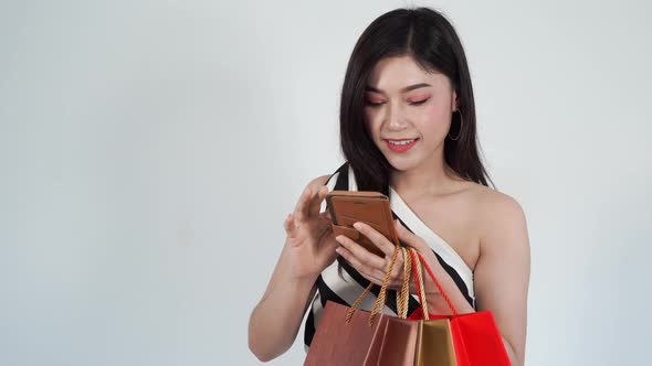 shopping woman holding bag and using smartphone