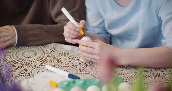 Hands Coloring Easter Eggs with Colors and Brush. alt