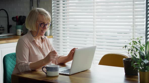 Video of senior woman during a video conference at home. Shot with RED helium camera in 8K. alt