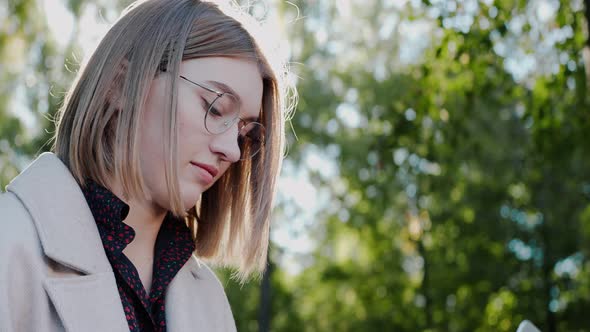 Closeup Shot of Young Girl Working on a Laptop at the Green Park in Autumn alt