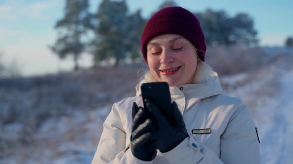Woman Looking at Smartphone Smile Stand at Winter Outdoors