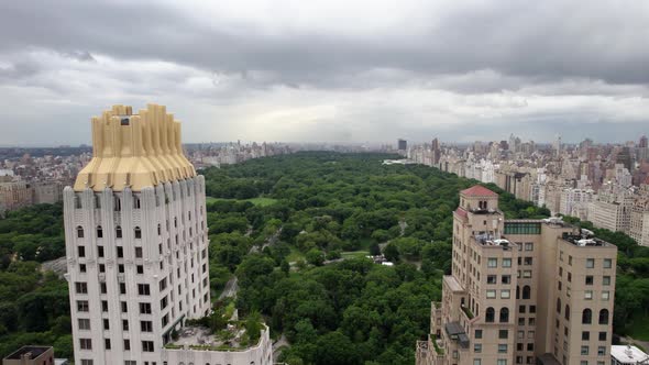Aerial view flying in middle of buildings, towards the Central Park, in cloudy NYC, USA alt