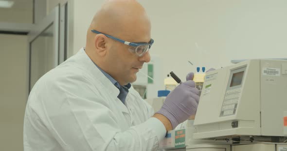 Scientist working with mass spectrometer in a pharmaceutical laboratory conducting experiments alt